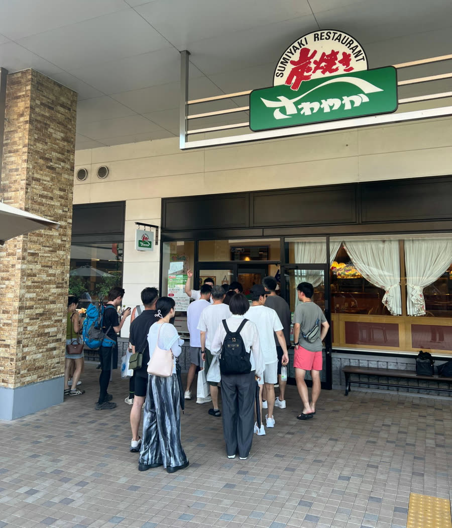 「炭焼きさわやか」の看板を掲げた店舗の入口に、お客様が集まっている様子