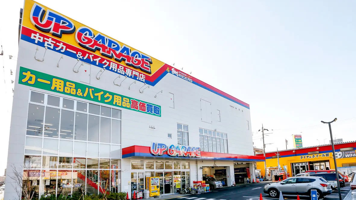 「UP GARAGE 中古カー＆バイク用品専門店」の看板を掲げたアップガレージの店舗外観