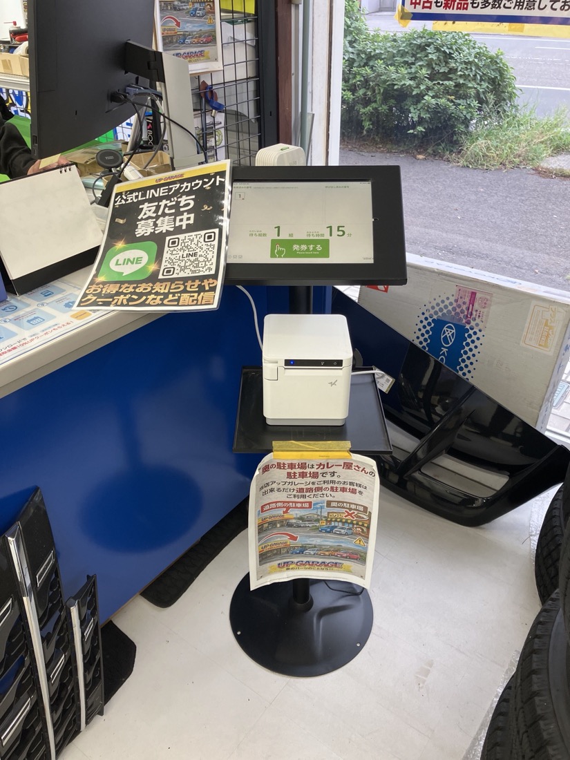 店内の入口付近に設置された、受付用タブレットとレシートプリンターのスタンド